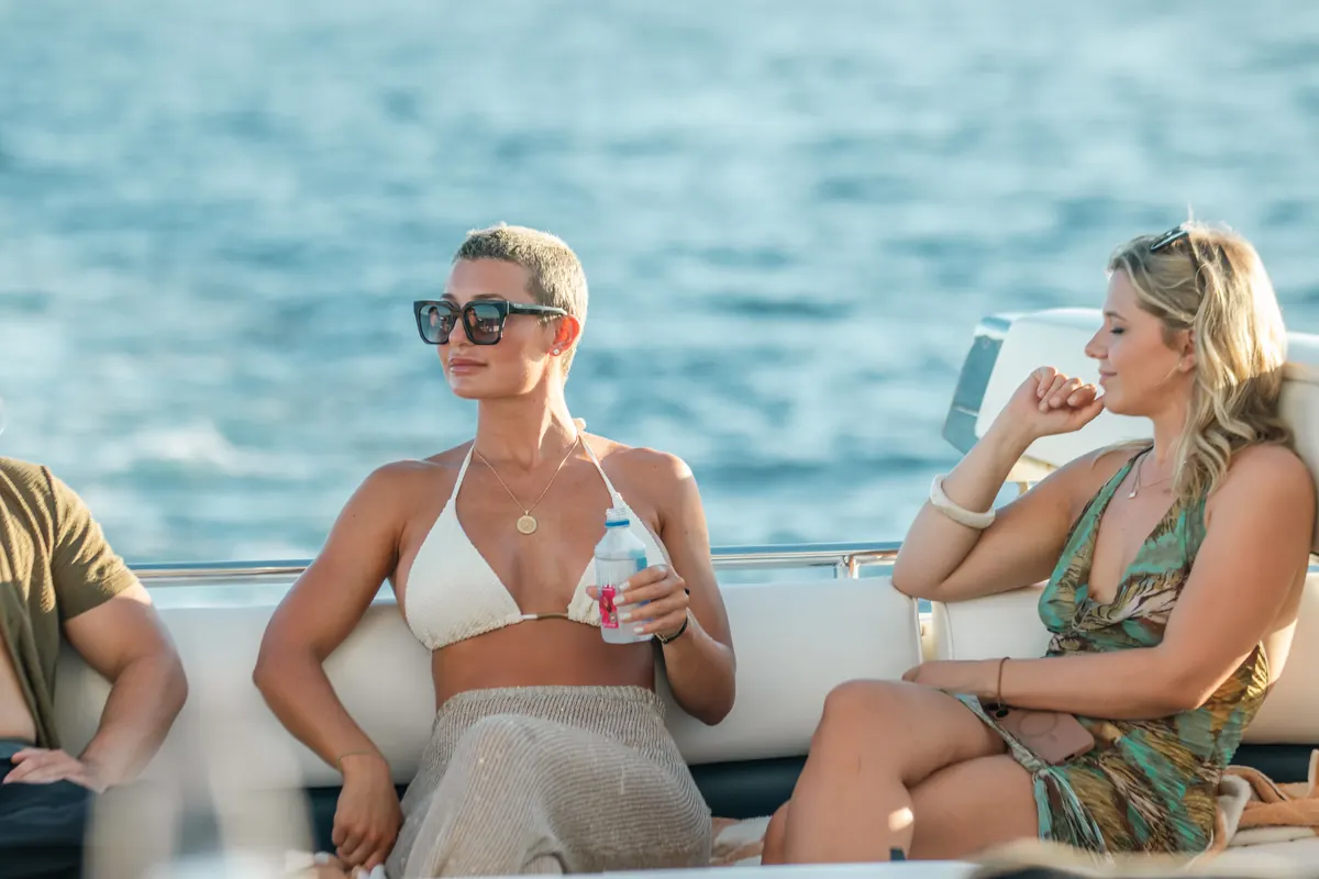 Guests relaxing with drinks on the 90ft party yacht deck