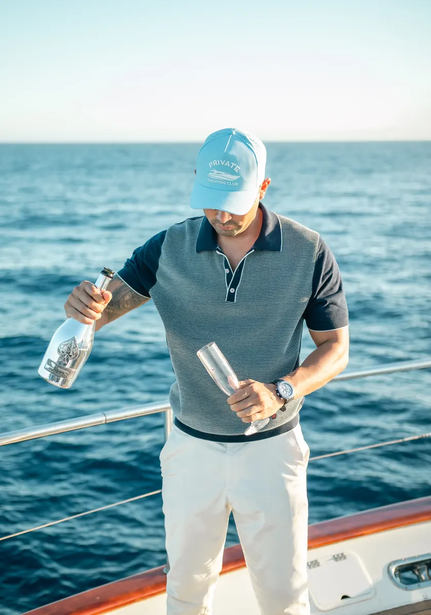 Guest pouring champagne on the Cabo party yacht